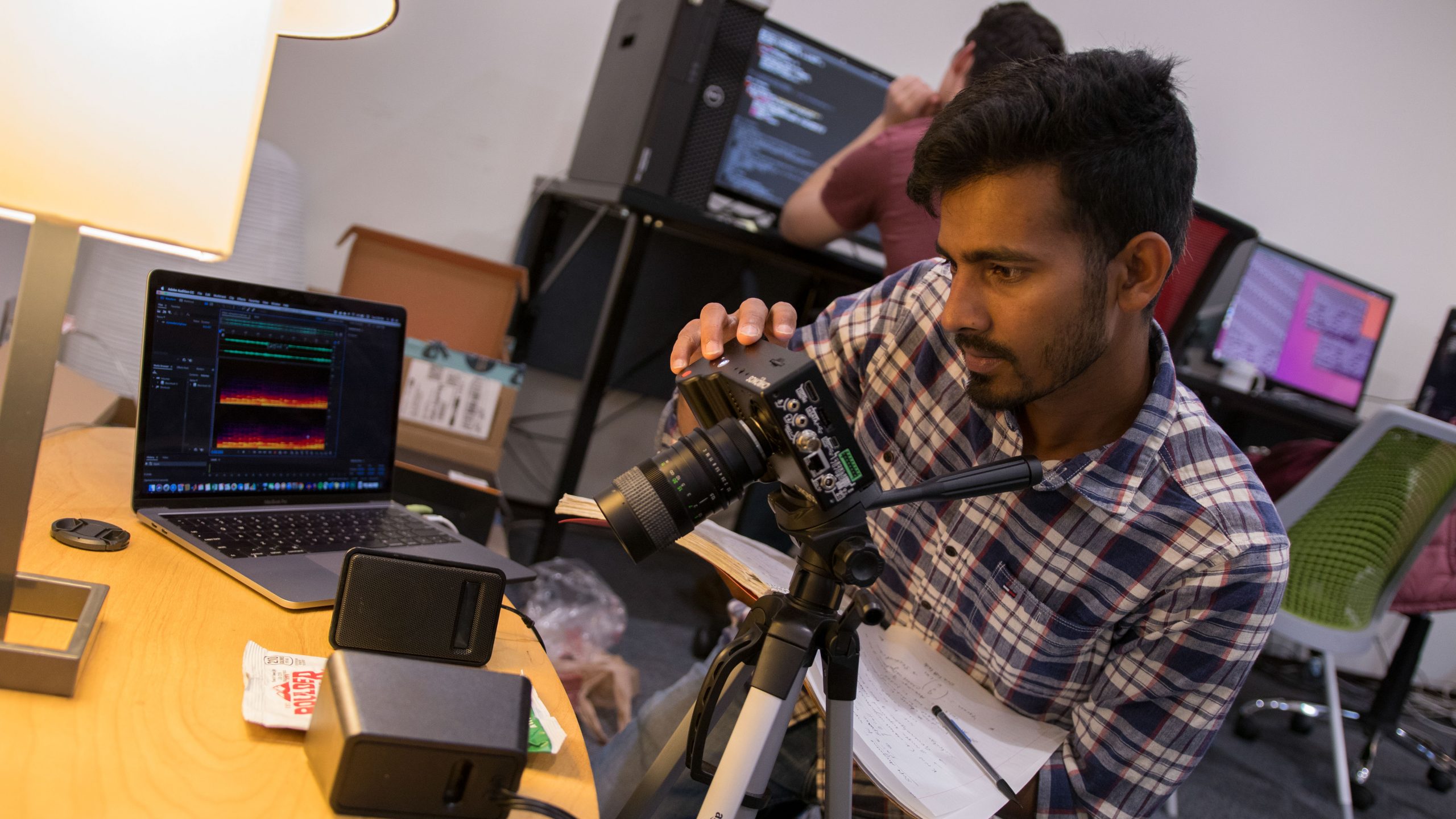 A student poses behind a camera
